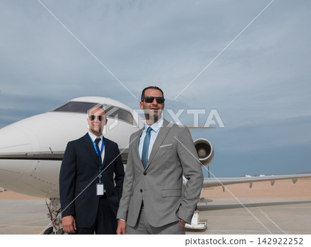 Middle Eastern business executives and security team standing in front of private jet on tarmac Middle Eastern business executives and security team standing in front of private jet on tarmac 142922252