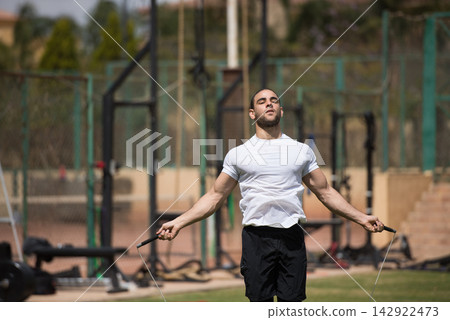 Middle Eastern man doing jump rope workout at outdoor CrossFit gym for fitness training and strength Middle Eastern man doing jump rope workout at outdoor CrossFit gym for fitness training and strength 142922473