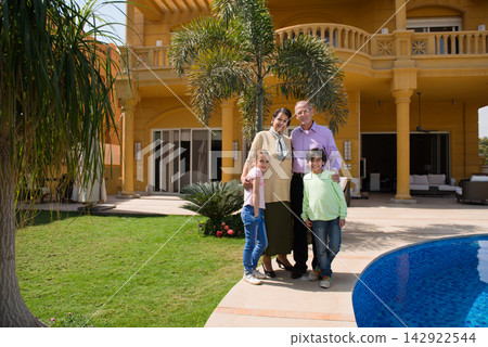 Modern Middle Eastern Arab family portrait with grandparents and grandchildren by luxury villa pool Modern Middle Eastern Arab family portrait with grandparents and grandchildren by luxury villa pool 142922544
