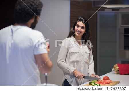 Middle Eastern couple preparing iftar dinner together in modern home kitchen during Ramadan celebration Middle Eastern couple preparing iftar dinner together in modern home kitchen during Ramadan celebration 142922807