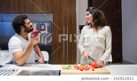 Middle Eastern couple preparing iftar dinner together at home during Ramadan and Eid celebrations Middle Eastern couple preparing iftar dinner together at home during Ramadan and Eid celebrations 142922812
