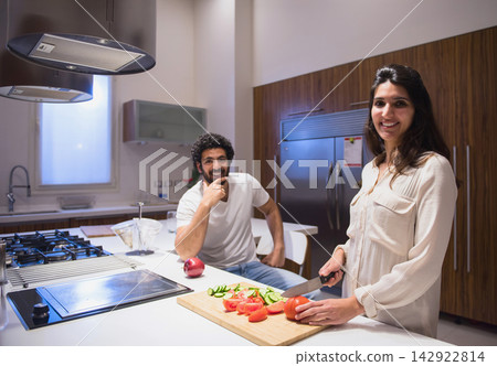 Middle Eastern modern family preparing iftar dinner together in a bright kitchen during Ramadan Eid celebration Middle Eastern modern family preparing iftar dinner together in a bright kitchen during Ramadan Eid celebration 142922814