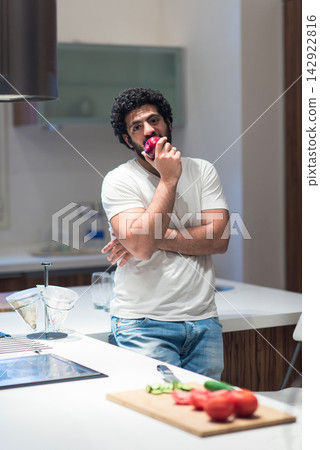 Middle Eastern man enjoying a relaxed iftar at home during Ramadan in a modern kitchen Middle Eastern man enjoying a relaxed iftar at home during Ramadan in a modern kitchen 142922816