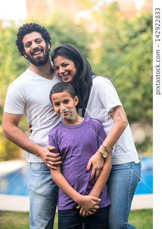 Middle Eastern family smiling together at home during Eid and Ramadan iftar celebration Middle Eastern family smiling together at home during Eid and Ramadan iftar celebration 142922833