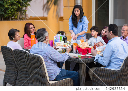 Middle Eastern family sharing Ramadan iftar dinner together at a modern home for Eid celebration 142922834