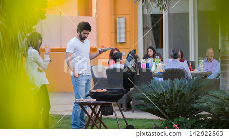 Modern Middle Eastern family celebrating Ramadan and Eid with iftar dinner and backyard barbecue 142922863