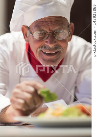 Elderly chef preparing iftar for a Middle Eastern modern family during Eid dinner at home Elderly chef preparing iftar for a Middle Eastern modern family during Eid dinner at home 142922869