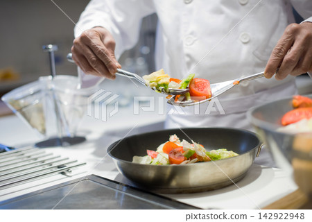 Chef preparing fresh vegetable dish for modern Middle Eastern iftar dinner during Ramadan and Eid family gathering Chef preparing fresh vegetable dish for modern Middle Eastern iftar dinner during Ramadan and Eid family gathering 142922948