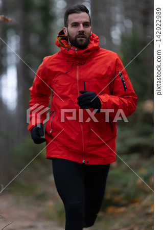 Man Running In Red Jacket On Forest Trail During Cold Weather Outdoor Workout Man Running In Red Jacket On Forest Trail During Cold Weather Outdoor Workout 142922989