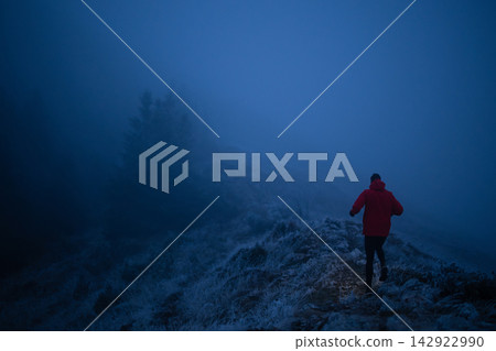 Runner in Red Jacket Jogging Through Foggy Frosted Mountain Ridge at Dusk Winter Trail Runner in Red Jacket Jogging Through Foggy Frosted Mountain Ridge at Dusk Winter Trail 142922990