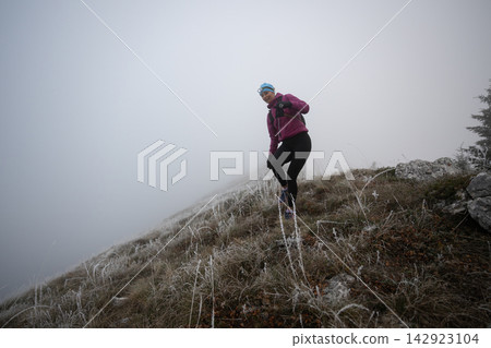 Trail Runner Woman Jogging Through Foggy Frosted Mountain Slope Wearing Headlamp And Winter Gear Trail Runner Woman Jogging Through Foggy Frosted Mountain Slope Wearing Headlamp And Winter Gear 142923104