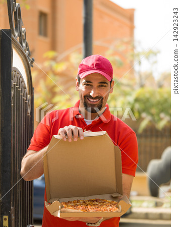 Smiling delivery man handing pizza boxes to Middle Eastern multi generation family at modern luxury villa Smiling delivery man handing pizza boxes to Middle Eastern multi generation family at modern luxury villa 142923243