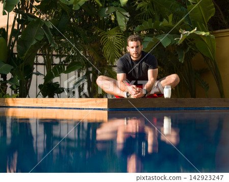 Middle Eastern man relaxing by pool at a luxury villa during family vacation with multi generation group Middle Eastern man relaxing by pool at a luxury villa during family vacation with multi generation group 142923247