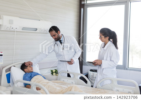 Middle Eastern doctors examining a young boy in an eye hospital clinic in Egypt, compassionate pediatric care team Middle Eastern doctors examining a young boy in an eye hospital clinic in Egypt, compassionate pediatric care team 142923706