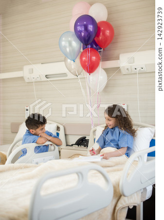 Children in a pediatric hospital room with balloons and smiling patients during recovery Children in a pediatric hospital room with balloons and smiling patients during recovery 142923739