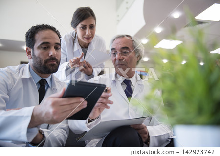 Middle Eastern eye hospital doctors reviewing patient data on tablet during team meeting at Egyptian clinic Middle Eastern eye hospital doctors reviewing patient data on tablet during team meeting at Egyptian clinic 142923742