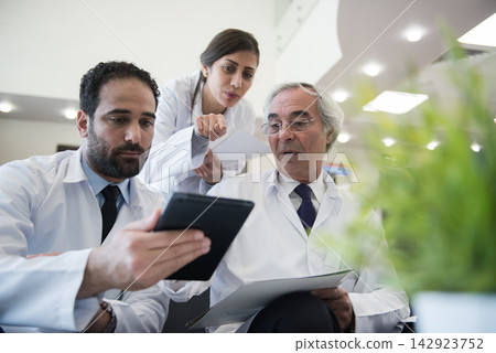 Medical team of doctors reviewing patient data in a modern Middle Eastern eye hospital clinic in Egypt Medical team of doctors reviewing patient data in a modern Middle Eastern eye hospital clinic in Egypt 142923752