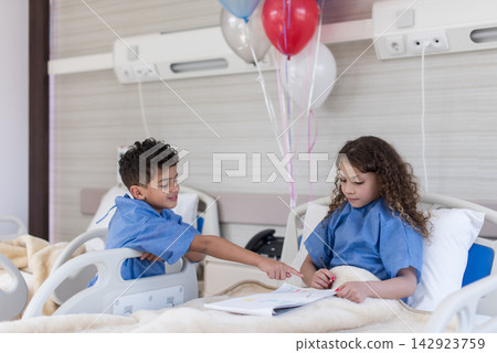 Two children patients in a Middle Eastern eye hospital ward in Egypt sharing drawings during recovery Two children patients in a Middle Eastern eye hospital ward in Egypt sharing drawings during recovery 142923759