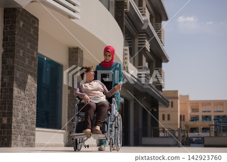 Middle Eastern nurse assisting a woman in a wheelchair outside an eye hospital clinic in Egypt Middle Eastern nurse assisting a woman in a wheelchair outside an eye hospital clinic in Egypt 142923760