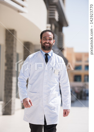 Middle Eastern eye doctor in white coat standing outside a modern eye clinic in Egypt Middle Eastern eye doctor in white coat standing outside a modern eye clinic in Egypt 142923770