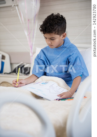 Young Middle Eastern boy patient drawing in hospital bed at an Egyptian pediatric clinic during recovery Young Middle Eastern boy patient drawing in hospital bed at an Egyptian pediatric clinic during recovery 142923780