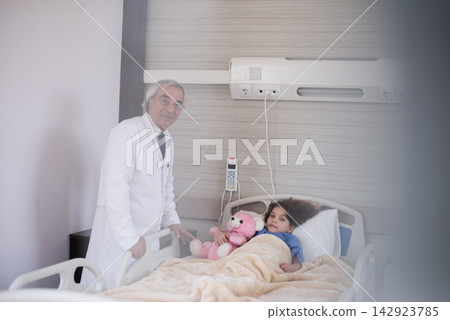 Doctor visiting young patient in a Middle Eastern eye hospital pediatric ward in Egypt 142923785