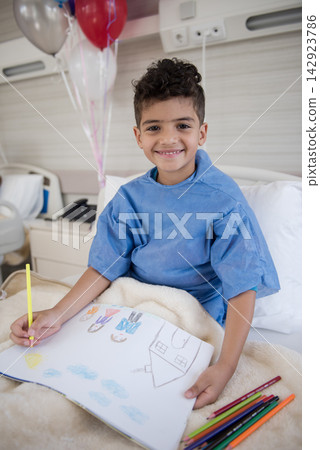 Smiling boy patient drawing in pediatric eye hospital bed with balloons in Egyptian clinic Smiling boy patient drawing in pediatric eye hospital bed with balloons in Egyptian clinic 142923786