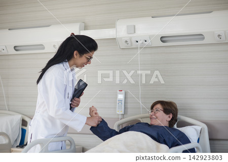 Female doctor comforting patient in modern eye hospital ward during recovery in Egypt clinic Female doctor comforting patient in modern eye hospital ward during recovery in Egypt clinic 142923803