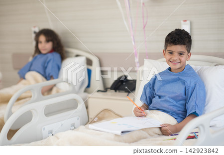 Smiling boy drawing in a modern Middle Eastern eye hospital ward during recovery in Egypt Smiling boy drawing in a modern Middle Eastern eye hospital ward during recovery in Egypt 142923842