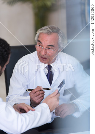 Senior doctor leading eye clinic consultation with surgical team in a modern Middle Eastern hospital in Egypt Senior doctor leading eye clinic consultation with surgical team in a modern Middle Eastern hospital in Egypt 142923869