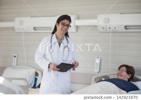 Female doctor consulting a smiling patient in a modern Middle Eastern eye hospital ward in Egypt Female doctor consulting a smiling patient in a modern Middle Eastern eye hospital ward in Egypt 142923870