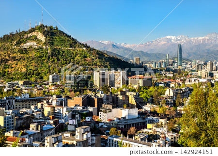 Panoramic view of the Santiago city skyline in Chile featuring San Cristobal Hill and the snow-capped Andes mountains under a clear blue sky. Panoramic view of the Santiago city skyline in Chile featuring San Cristobal Hill and the snow-capped Andes mountains under a clear blue sky. 142924151