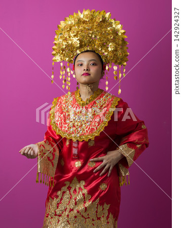 Young Indonesian Asian Woman in Red Traditional Costume With Ornate Gold Headdress Portrait Celebrating Cultural Heritage Young Indonesian Asian Woman in Red Traditional Costume With Ornate Gold Headdress Portrait Celebrating Cultural Heritage 142924327