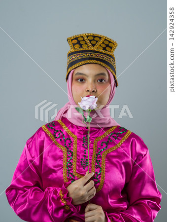 Young Indonesian Asian Woman in Traditional Pink Costume and Hijab Holding a Rose Portrait 142924358