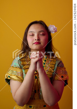 Young Indonesian Asian Woman Praying With Eyes Closed in Traditional Embroidered Dress and Flower Hair Accessory Portrait Young Indonesian Asian Woman Praying With Eyes Closed in Traditional Embroidered Dress and Flower Hair Accessory Portrait 142924404