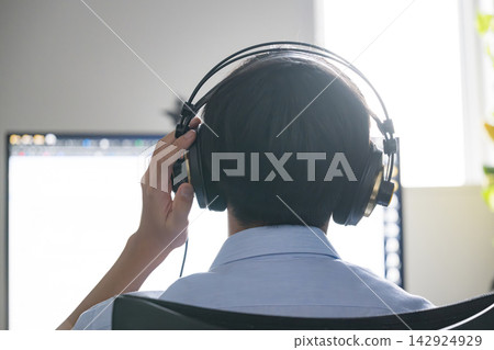 High school students wearing headphones and using their computers for online learning, working on listening comprehension at home, listening to music. High school students wearing headphones and using their computers for online learning, working on listening comprehension at home, listening to music. 142924929