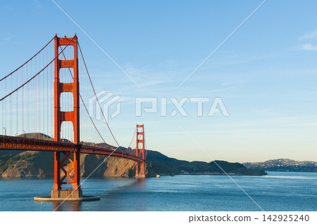 The Golden Gate Bridge and the bay, with the morning blue sky and its reflection on the water. 142925240