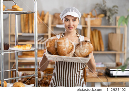 Young woman with homemade bread in bakery Young woman with homemade bread in bakery 142925402