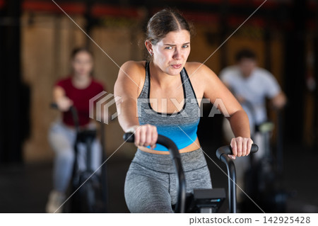 Woman in the top is engaged in an airbike Woman in the top is engaged in an airbike 142925428