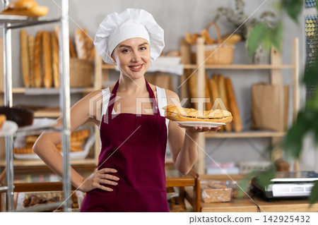 Young woman seller with bocadillo in bakery Young woman seller with bocadillo in bakery 142925432