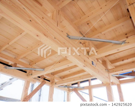 The structure of beams and bracing metal fittings visible after the frame is erected in a wooden house. The structure of beams and bracing metal fittings visible after the frame is erected in a wooden house. 142925620