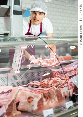 Guy seller works in specialized butcher shop Guy seller works in specialized butcher shop 142925710