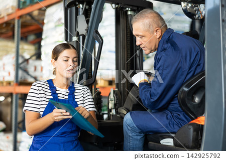 Young woman and elderly man working on loader check documents 142925792