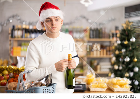 Man choosing champagne in a supermarket Man choosing champagne in a supermarket 142925825