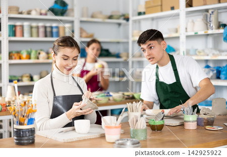 Young woman and young man making pottery Young woman and young man making pottery 142925922