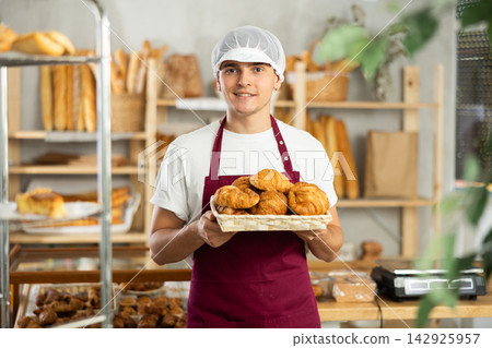 Diligent guy baker offers to buy fresh delicious croissants Diligent guy baker offers to buy fresh delicious croissants 142925957