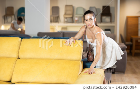 Adult woman chooses sofa in store 142926094