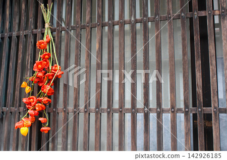 Autumn red Chinese lanterns stand out against the Japanese-style wooden lattice. 142926185