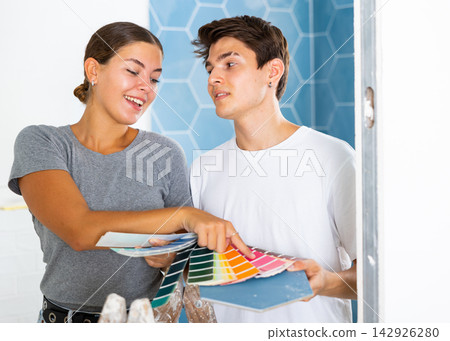 Young couple selects a harmonious color of paint with existing tiles Young couple selects a harmonious color of paint with existing tiles 142926280
