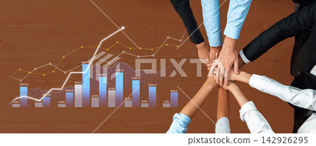 Diverse Team Collaborating on Business Strategy with Hands Together Over Financial Graphs and Growth Charts in Professional Setting Scalp Diverse Team Collaborating on Business Strategy with Hands Together Over Financial Graphs and Growth Charts in Professional Setting Scalp 142926295